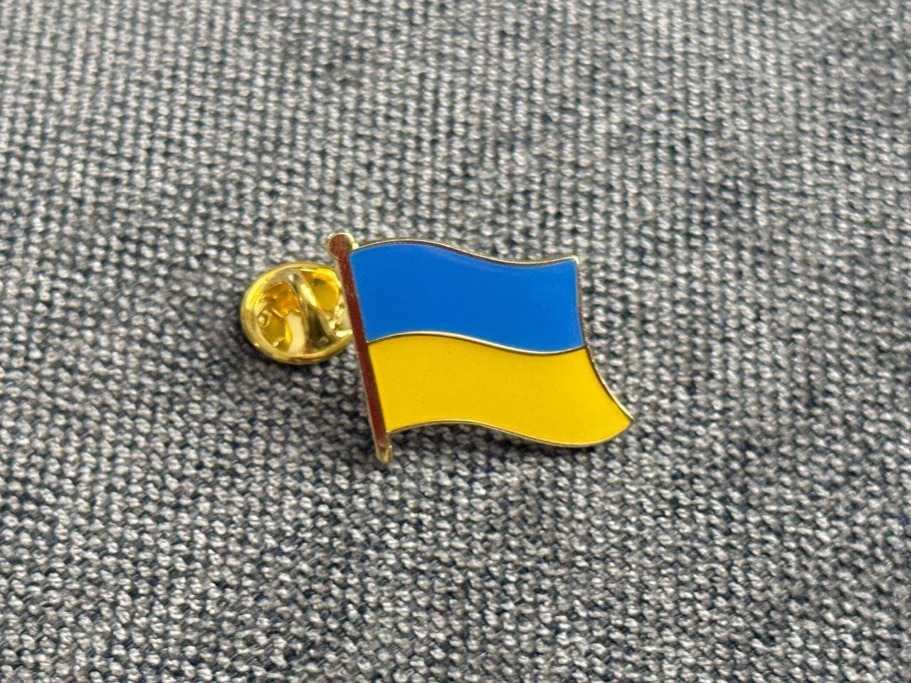 A pin with the design of the Ukrainian flag.