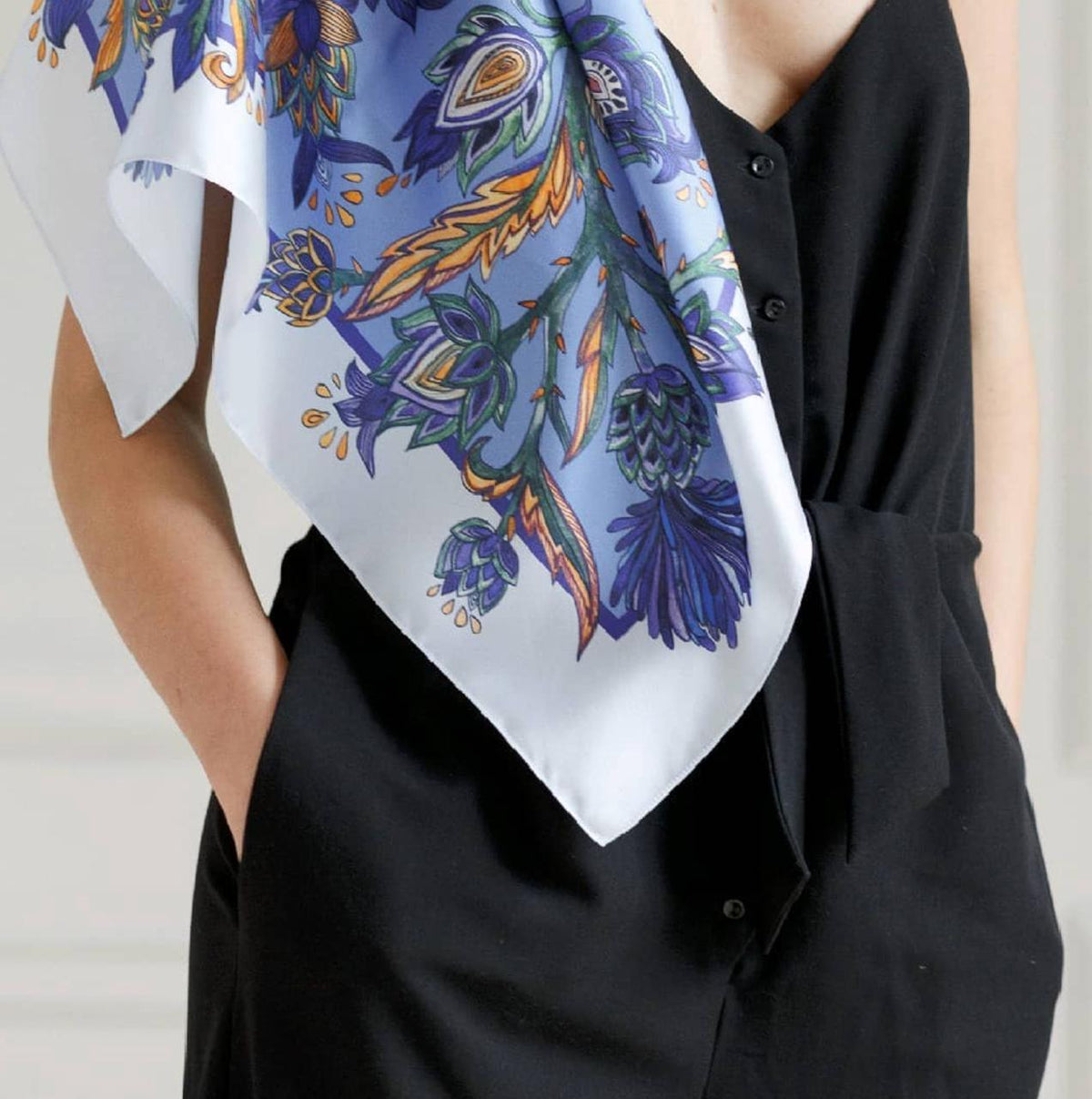 white scarf with a blue, purple, and orange botanical print.