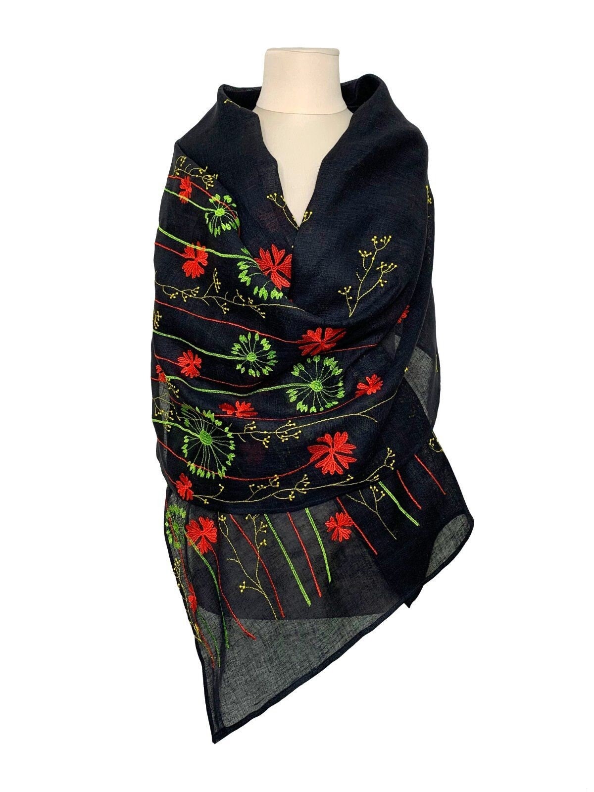 A black linen shawl with embroidered floral patterns displayed on a mannequin.