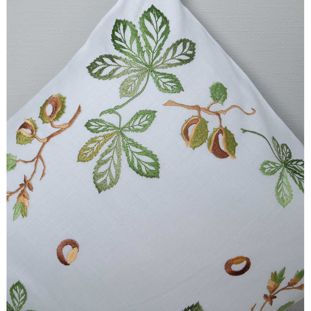 Embroidered fabric with green leaves and brown branches on a white background