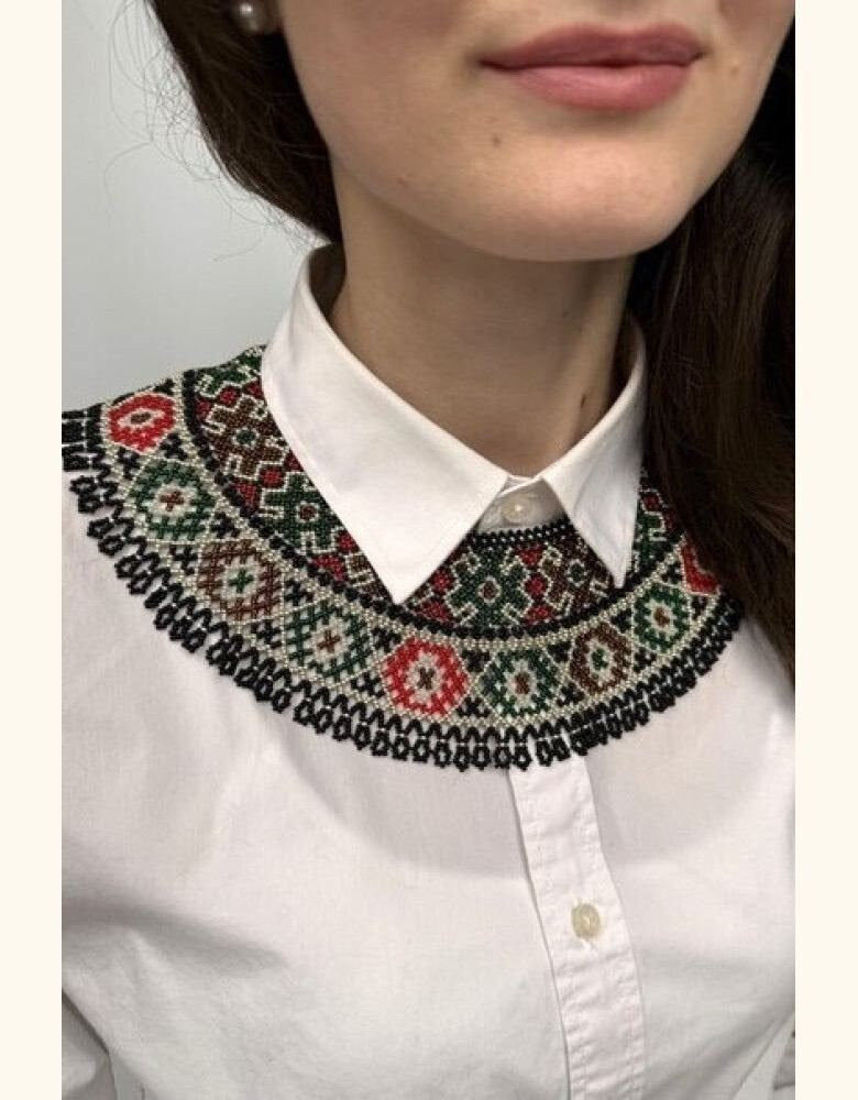accessorized with a green, beige, and red beaded vyshyvanka collar necklace.