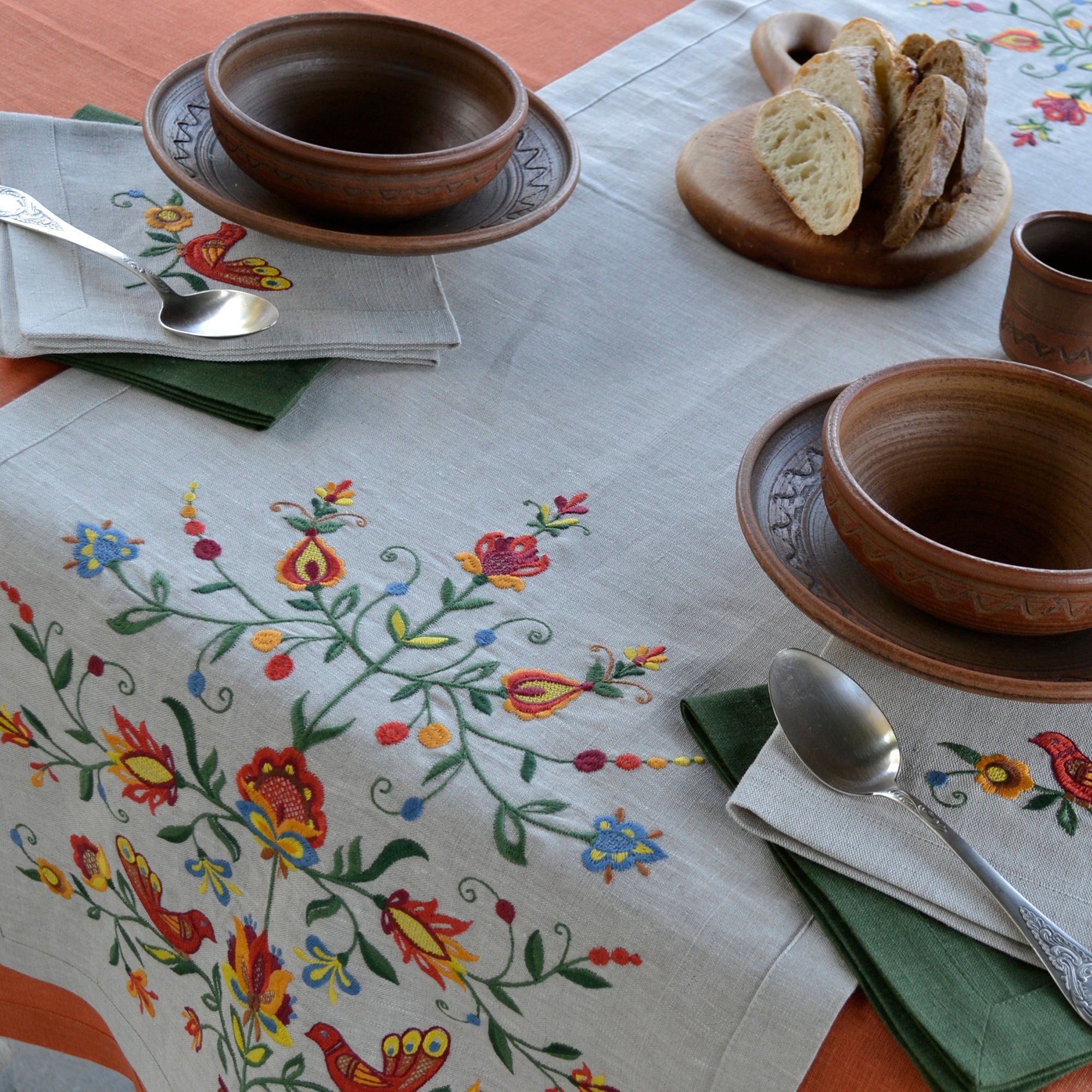 embroidered table runner with a colorful floral and bird pattern
