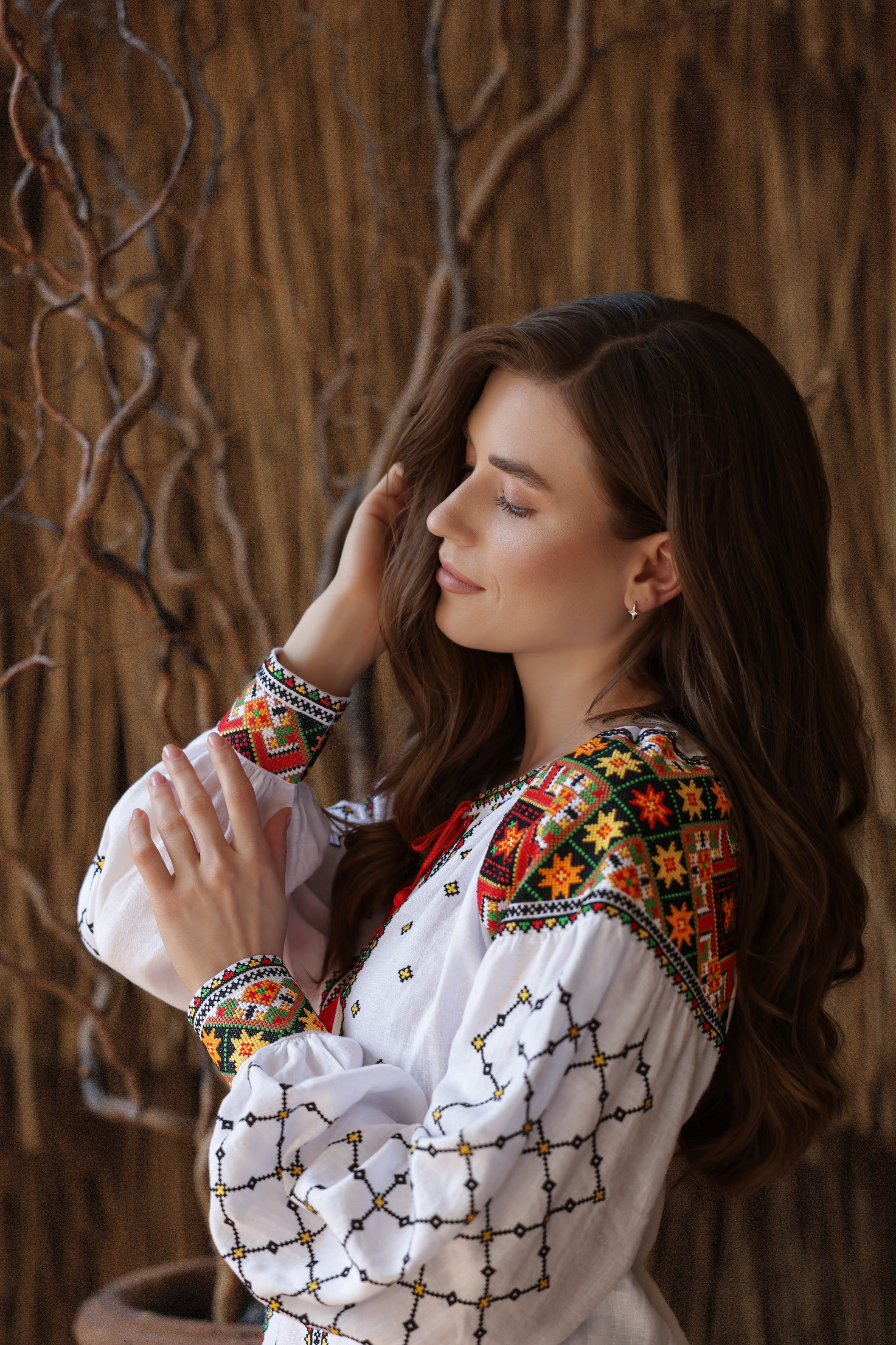 Woman wearing a traditional embroidered blouse against a natural background