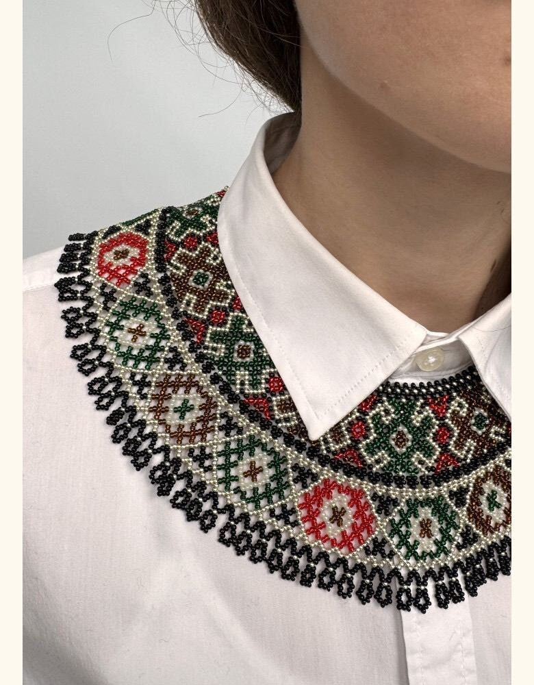accessorized with a green, beige, and red beaded vyshyvanka collar necklace
