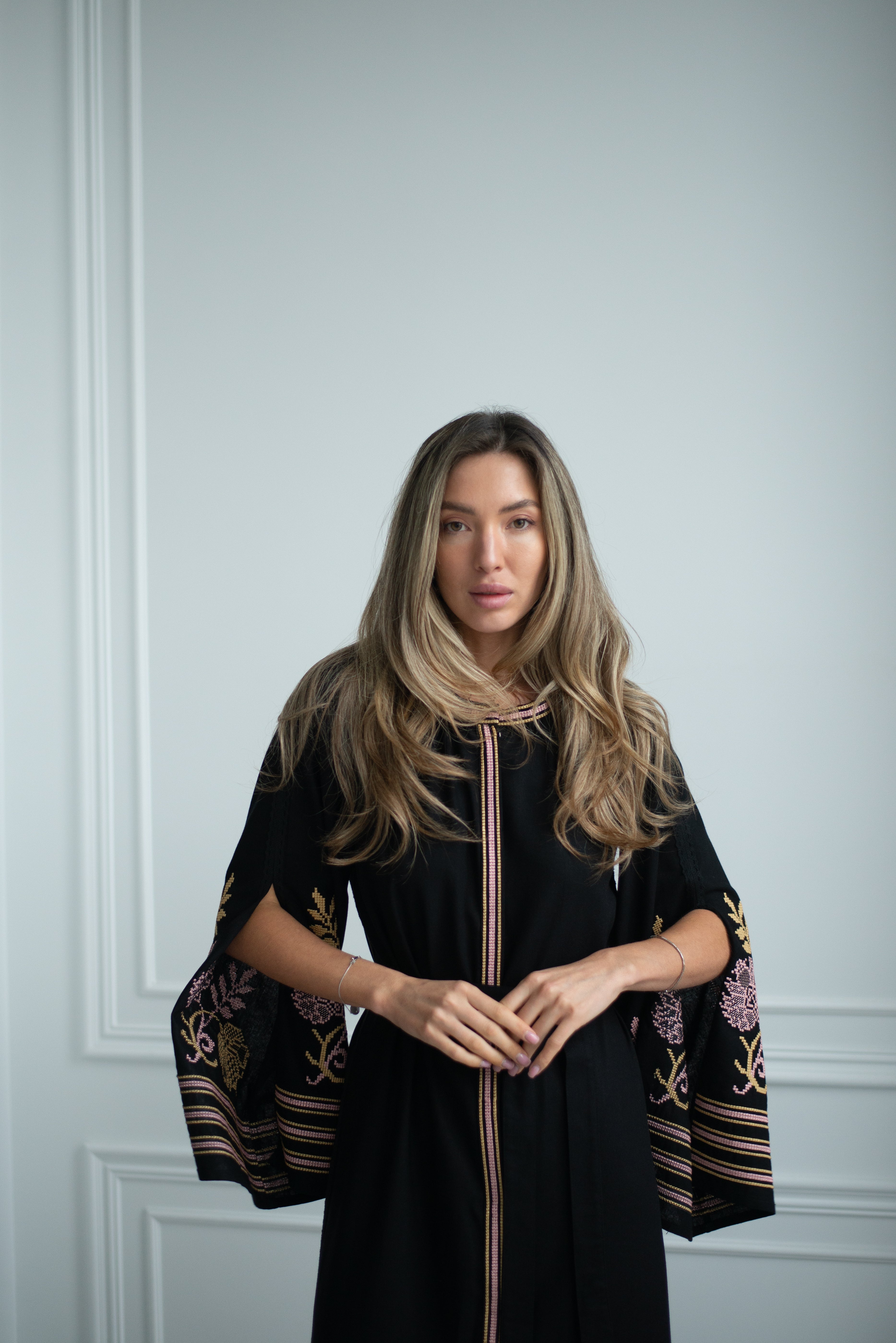 black linen contrasts with muted powder-gold embroidery