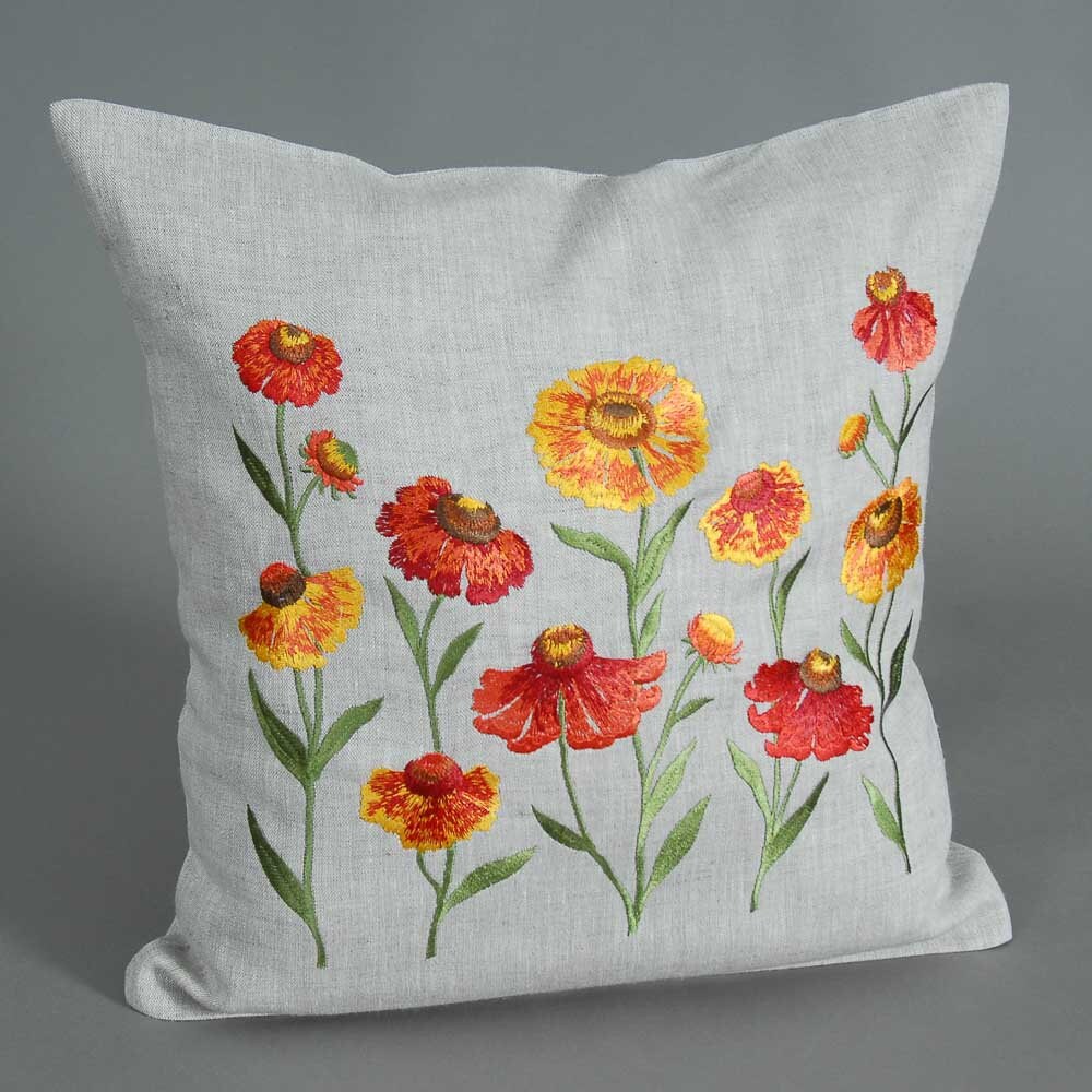 A gray linen pillowcase with embroidered floral patterns in the center, displayed against a grey background.