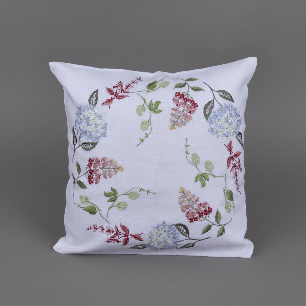 Decorative pillow with floral embroidery on a gray background