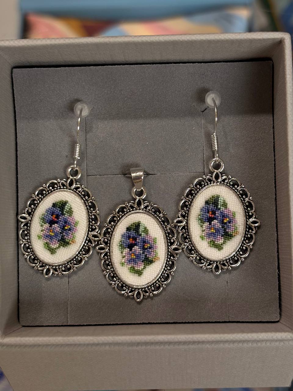 Delicate embroidered jewelry set featuring tiny floral motifs created with silk thread and framed in elegant metal findings. 
