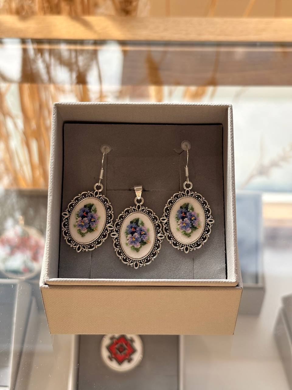 Delicate embroidered jewelry set featuring tiny floral motifs created with silk thread and framed in elegant metal findings. 