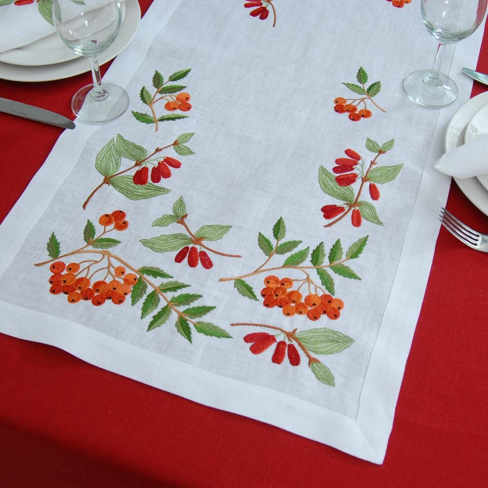  white linen tablecloth and four napkins with embroidered red and green floral 